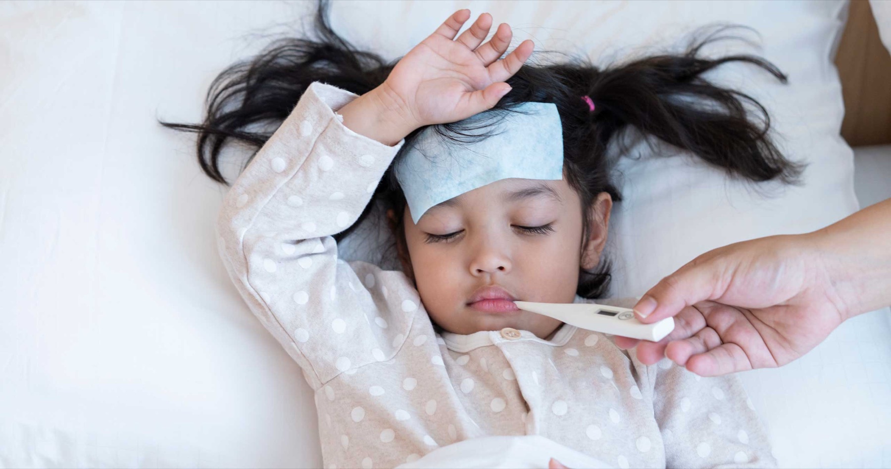 Imagen representativa de una persona adulta cuidando a una niña con fiebre